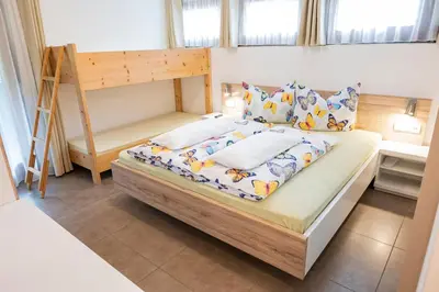 a small bedroom with a bunk bed and a ladder at Garni Birkenau in San Martino