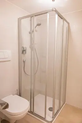 a shower stall in a bathroom with a toilet at Garni Birkenau in San Martino