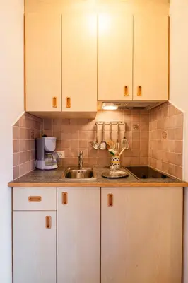 a kitchen with white cabinets and a sink at Garni Birkenau in San Martino
