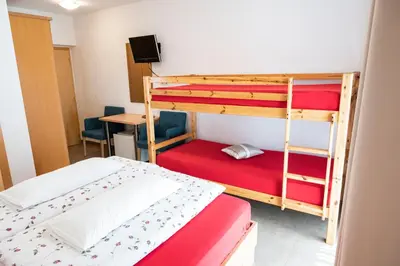 a bedroom with two bunk beds and a desk at Garni Birkenau in San Martino