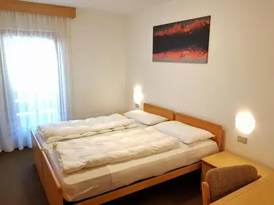 a bedroom with two beds and a window at Residence La Zondra in Pozza di Fassa