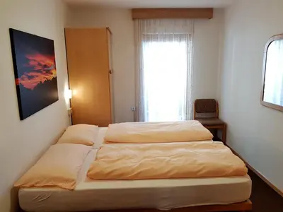 a bedroom with two beds and a window at Residence La Zondra in Pozza di Fassa