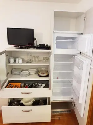 a white refrigerator with its door open with food at Residence La Zondra in Pozza di Fassa