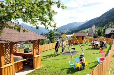 a group of people playing in a park at Residence La Zondra in Pozza di Fassa