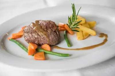 a plate of food with a piece of meat and vegetables at Hotel Schönblick in Maranza