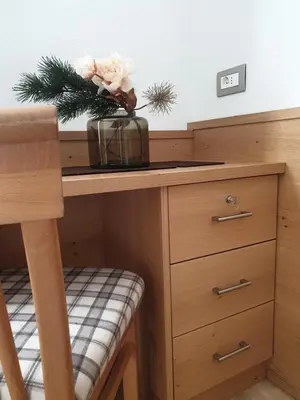 a wooden desk with a vase of flowers on it at Garni Le Chalet in Santa Cristina in Val Gardena