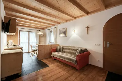 a bedroom with a bed with a red and white blanket at Apartments Isgla in Selva di Val Gardena