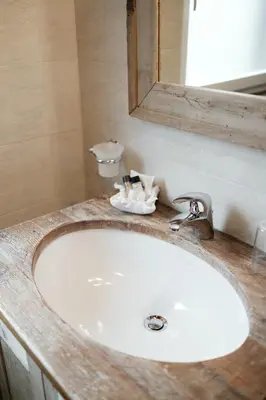 a white sink in a bathroom with a mirror at Apartments Isgla in Selva di Val Gardena