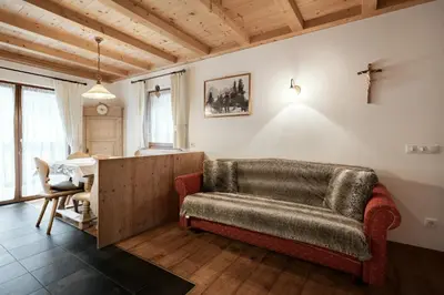 a living room with a couch and a table at Apartments Isgla in Selva di Val Gardena
