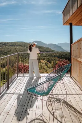 a woman standing on top of a balcony at Hotel am Hang in Soprabolzano