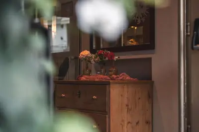 a table with flowers in vases on top of it at Schwarzer Adler in Siusi