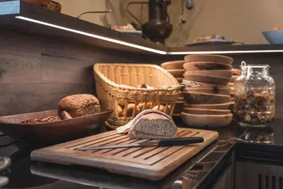 a kitchen counter with a cutting board and baskets at Schwarzer Adler in Siusi