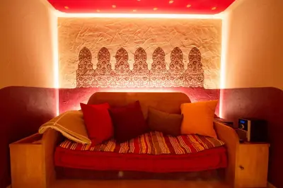 a couch with colorful pillows in a room at Schwarzer Adler in Siusi