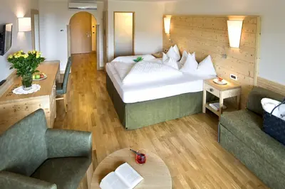 a hotel room with a large bed and two couches at Schwarzer Adler in Siusi