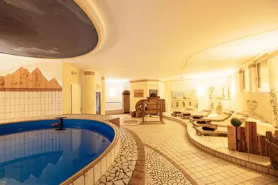 a large room with a swimming pool in a building at Hotel Wildschütz in San Leonardo in Passiria