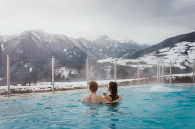 a man and a woman sitting in a swimming pool at Hotel Schönblick in Rodengo