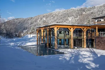 a wine tasting room with a table and wine bottles at Hotel Pustertalerhof in Chienes
