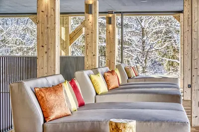 a sauna with wooden walls and benches and a window at Hotel Pustertalerhof in Chienes