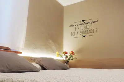 a bedroom with a bed with a vase of flowers on it at B&B Casa Vanzetta in Ziano di Fiemme