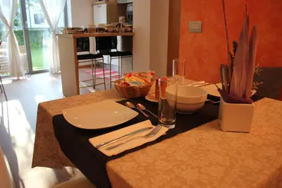 a table with plates and utensils on top of it at B&B Casa Vanzetta in Ziano di Fiemme