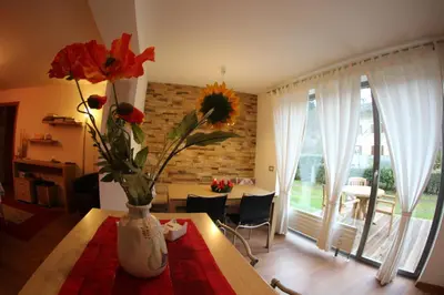 a vase with flowers on a table in a room at B&B Casa Vanzetta in Ziano di Fiemme