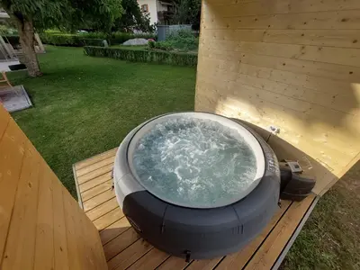 a hot tub sitting on top of a wooden deck at B&B Casa Vanzetta in Ziano di Fiemme