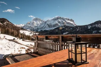a wooden deck with a view of a snow covered mountain at Apartments Rit in La Valle