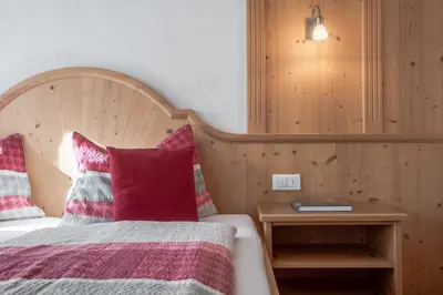 a bedroom with a bed with red and pink pillows at Apartments Rit in La Valle