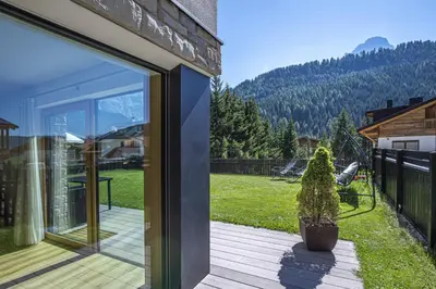 a sliding glass door of a house with a potted plant at Apartment Villa Valeria in Selva di Val Gardena