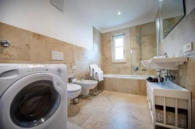 a bathroom with a washer and a washing machine in it at Apartment Villa Valeria in Selva di Val Gardena