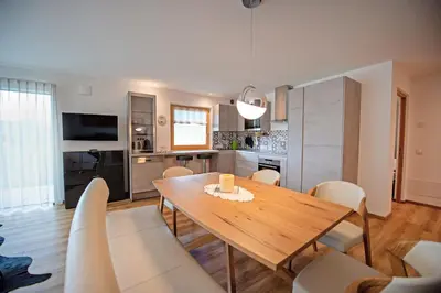 a kitchen and dining room with a wooden table and chairs at Apartment Villa Valeria in Selva di Val Gardena