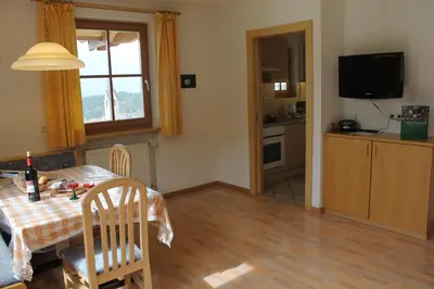 a kitchen and dining room with a table and a television at Beikircherhof in San Lorenzo di Sebato