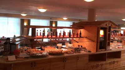 a kitchen with a counter with many bottles of wine at Hotel Stella Montis in Campitello di Fassa