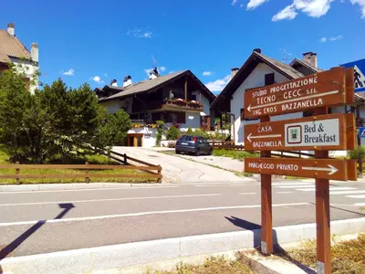 a directional sign in front of a street with houses at B&B Casa Bazzanella in Cavalese