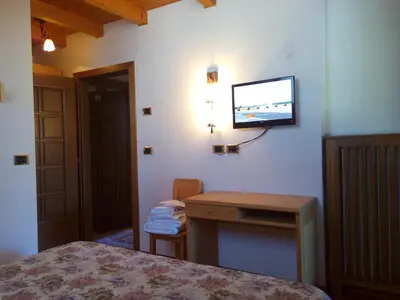 a bedroom with a blue bed with wooden ceilings at B&B Casa Bazzanella in Cavalese