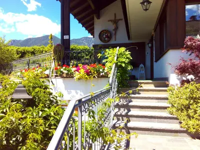 a building with a balcony and flowers on it at B&B Casa Bazzanella in Cavalese