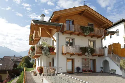a white building with balconies and plants on it at Villa Prafiorì in Cavalese