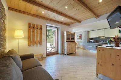 a living room with a couch and a kitchen at Villa Prafiorì in Cavalese