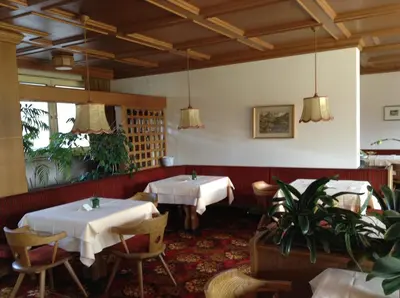 a restaurant with two tables with white table cloth at Hotel Tannerhof in Merano