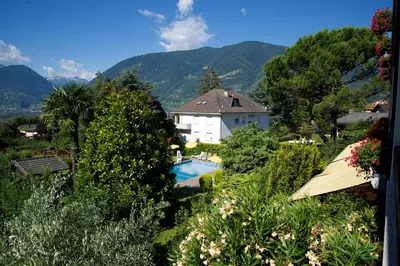 a house in the mountains with a swimming pool at Hotel Tannerhof in Merano
