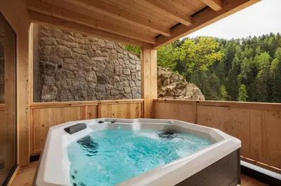 a jacuzzi tub in a cabin with a window at Mountain Village Hasenegg in Schenna