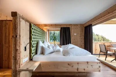 a bedroom with a bed with white pillows at Mountain Village Hasenegg in Schenna