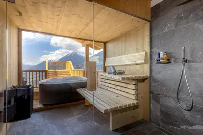 a bathroom with a tub and a shower with a view at Mountain Village Hasenegg in Schenna