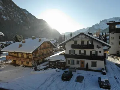 a group of buildings with snow on the roofs at Appartamenti Ladina in Campitello di Fassa