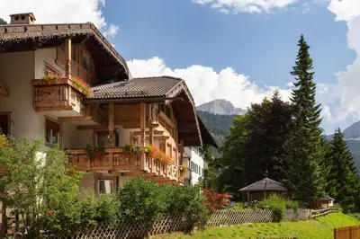 a building with balconies and flowers on it at Appartamenti Ladina in Campitello di Fassa