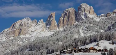 a mountain range with a lodge in the snow at Appartamenti Ladina in Campitello di Fassa