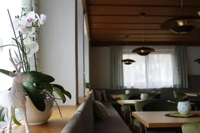 a living room with a couch and a vase of flowers at Appartments Jägerhof in Valdaora