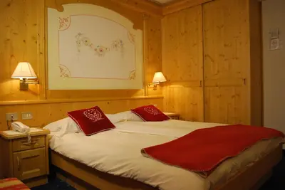 a bedroom with a bed with red pillows on it at Piccolo Hotel in Canazei