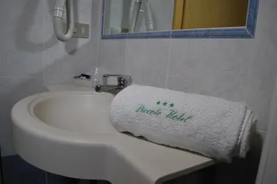 a white bathroom sink with a towel on it at Piccolo Hotel in Canazei