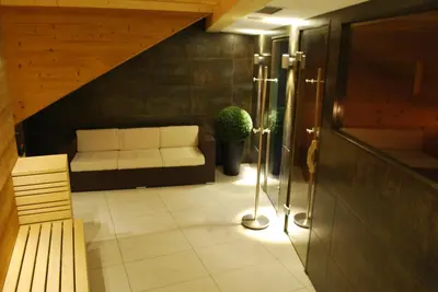 a living room with a couch and a bench at Piccolo Hotel in Canazei